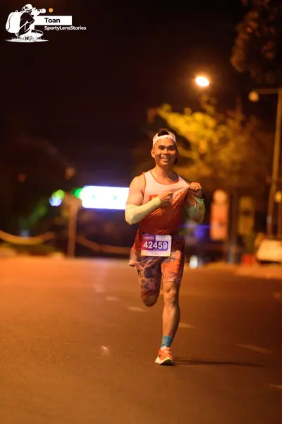 Marathon runner #42459: Runner 1: orange tank top, patterned shorts, white headband, white arm sleeves, 