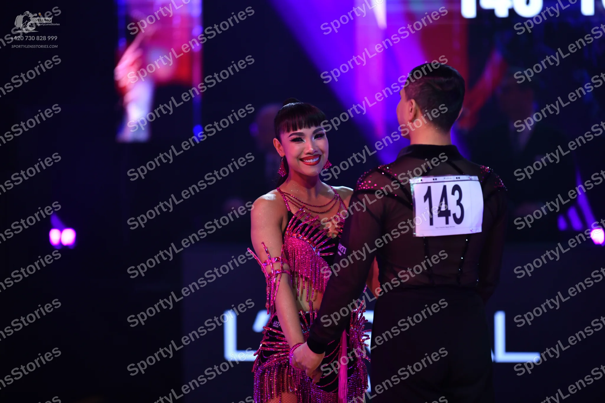 Dancesport competitor: Male dancer: black long-sleeved top with sheer mesh panels and small sparkly acc