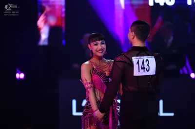 Dancesport competitor: Male dancer: black long-sleeved top with sheer mesh panels and small sparkly acc