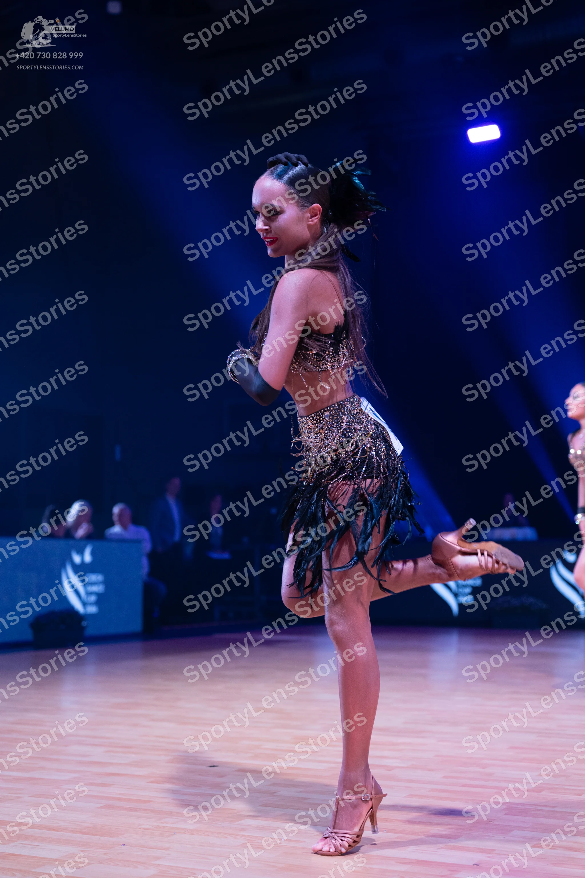 Dancesport competitor: Female dancer: dark, sequined Latin dance costume with a long black fringe skirt