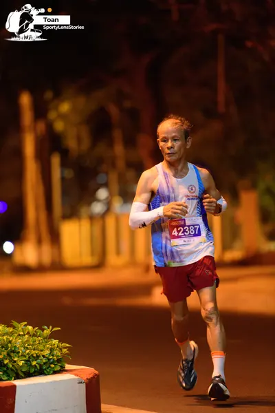 Marathon runner #42387: Runner 1: blue and white patterned tank top, maroon shorts, white compression sl