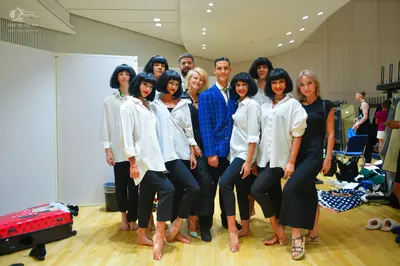 Dancesport competitor: Group of female dancers: matching white long-sleeved button-down shirts and blac