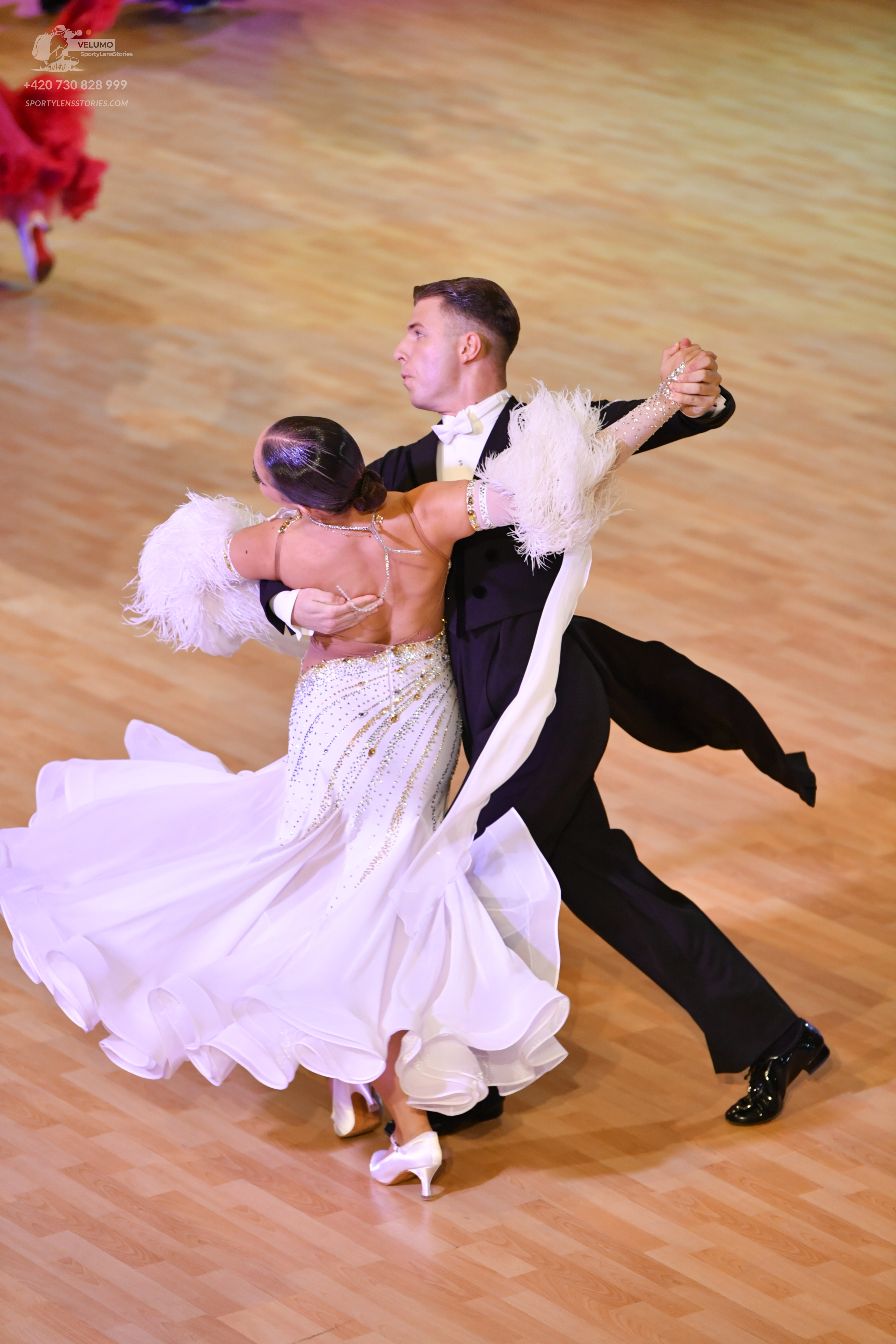 Dancesport competitor: Male:** Black tail suit with a white sequined lapel and a white bow tie
