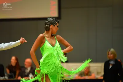 Dancesport competitor: Female dancer: lime green latin dress with long fringe and sequins