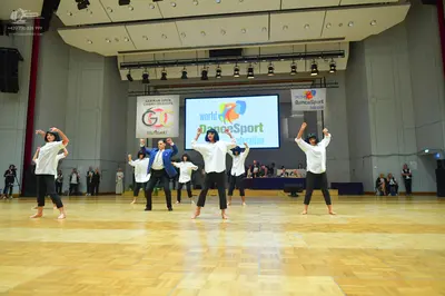 Dancesport competitor: Female dancers: white short-sleeved shirts and black cropped pants, barefoot