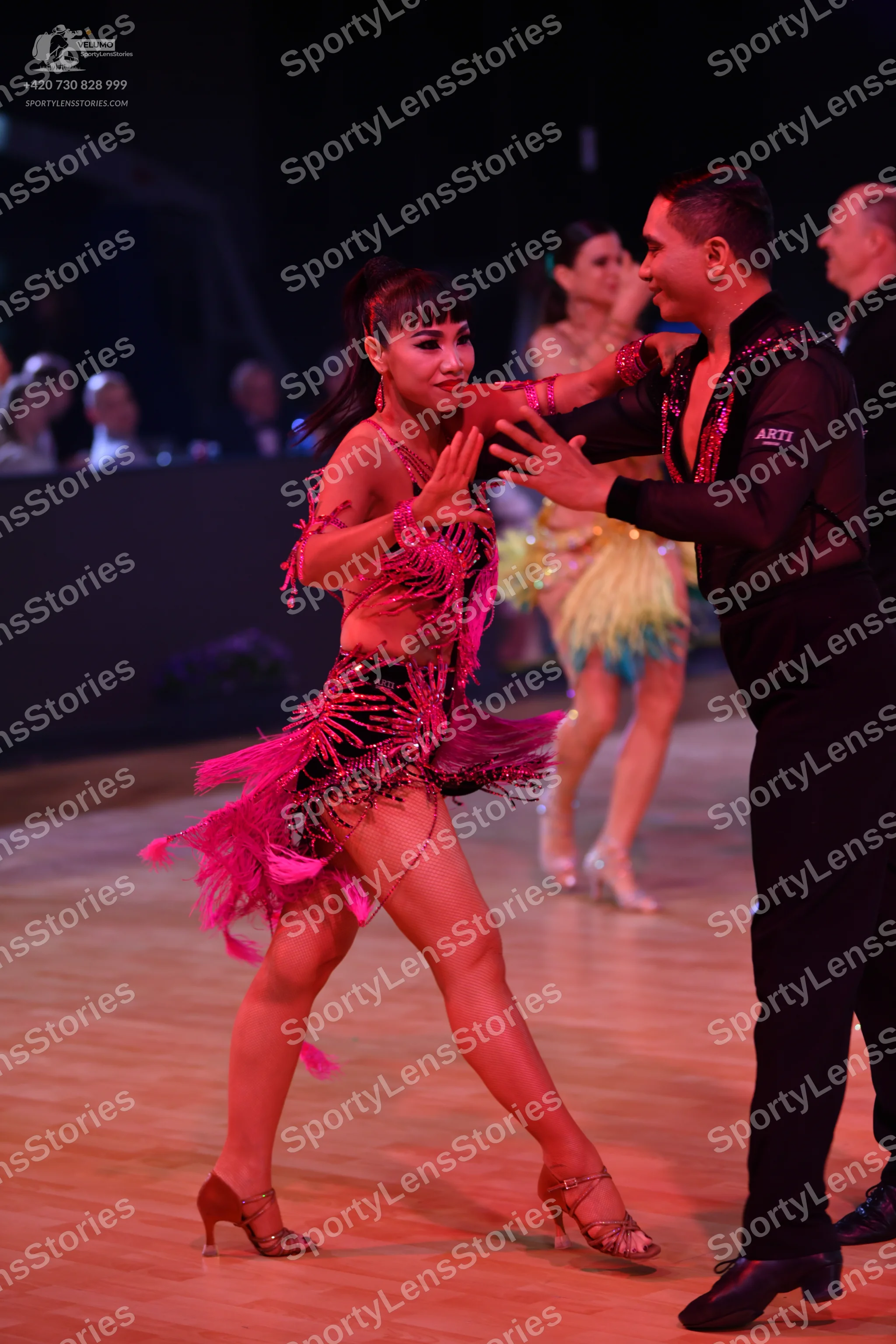 Dancesport competitor: Main female dancer: magenta Latin dance dress with extensive fringe and sequin d