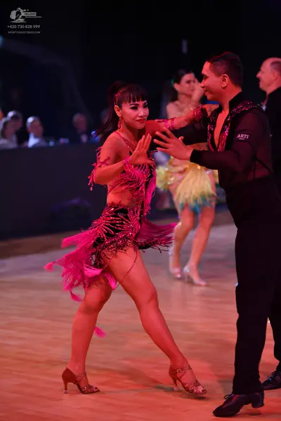 Dancesport competitor: Main female dancer: magenta Latin dance dress with extensive fringe and sequin d