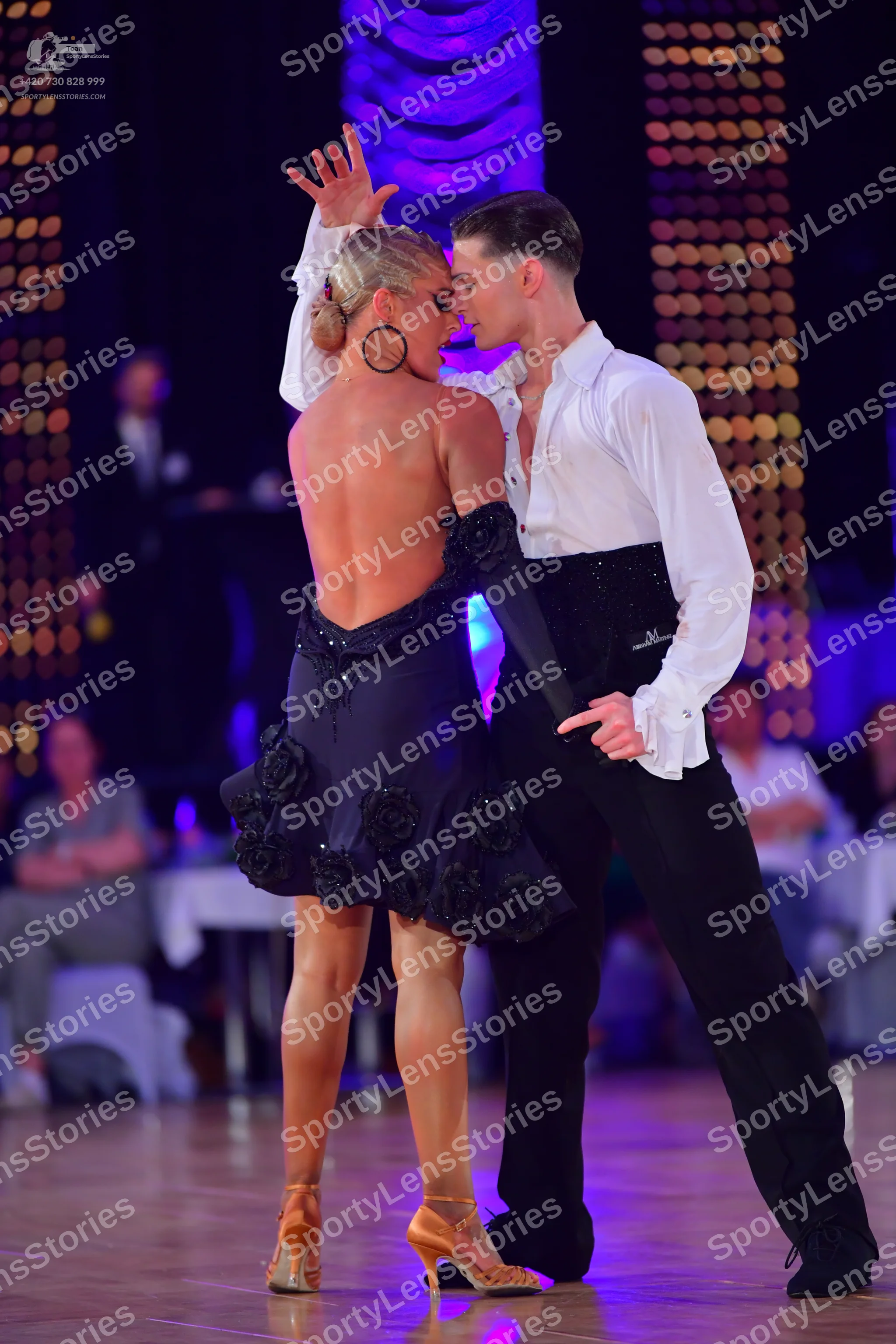 Dancesport competitor: Female dancer: backless dark navy/black Latin dress with 3D floral embellishment