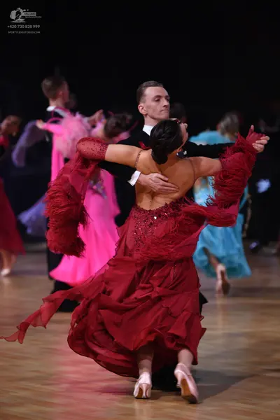 Dancesport competitor: Male dancer: black suit with a white shirt cuff visible