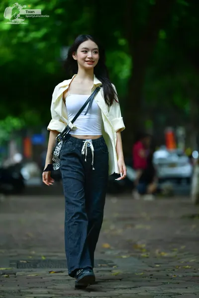 Dancesport competitor: The person in the foreground is wearing a white tank top, an unbuttoned cream-co