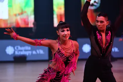 Dancesport competitor: Female dancer: pink/magenta latin dress with sequins and fringe
