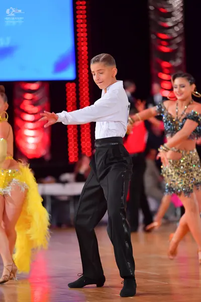 Dancesport competitor: Male dancer: white long-sleeved shirt and black trousers with a satin side strip