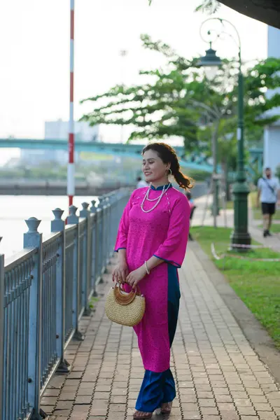 Dancesport competitor: Female dancer: long pink dress with long sleeves and a side slit revealing a nav
