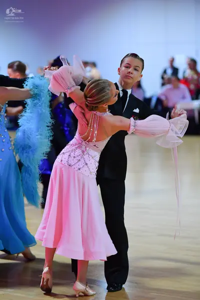 Dancesport competitor: Male dancer: black suit, white shirt, black tie, and white pocket square