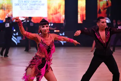 Dancesport competitor: Female dancer: bright pink Latin dance dress with long fringe and matching pink 