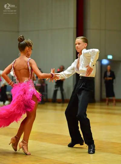Dancesport competitor: Female dancer: bright pink latin dress with fringe and sequin embellishments on 