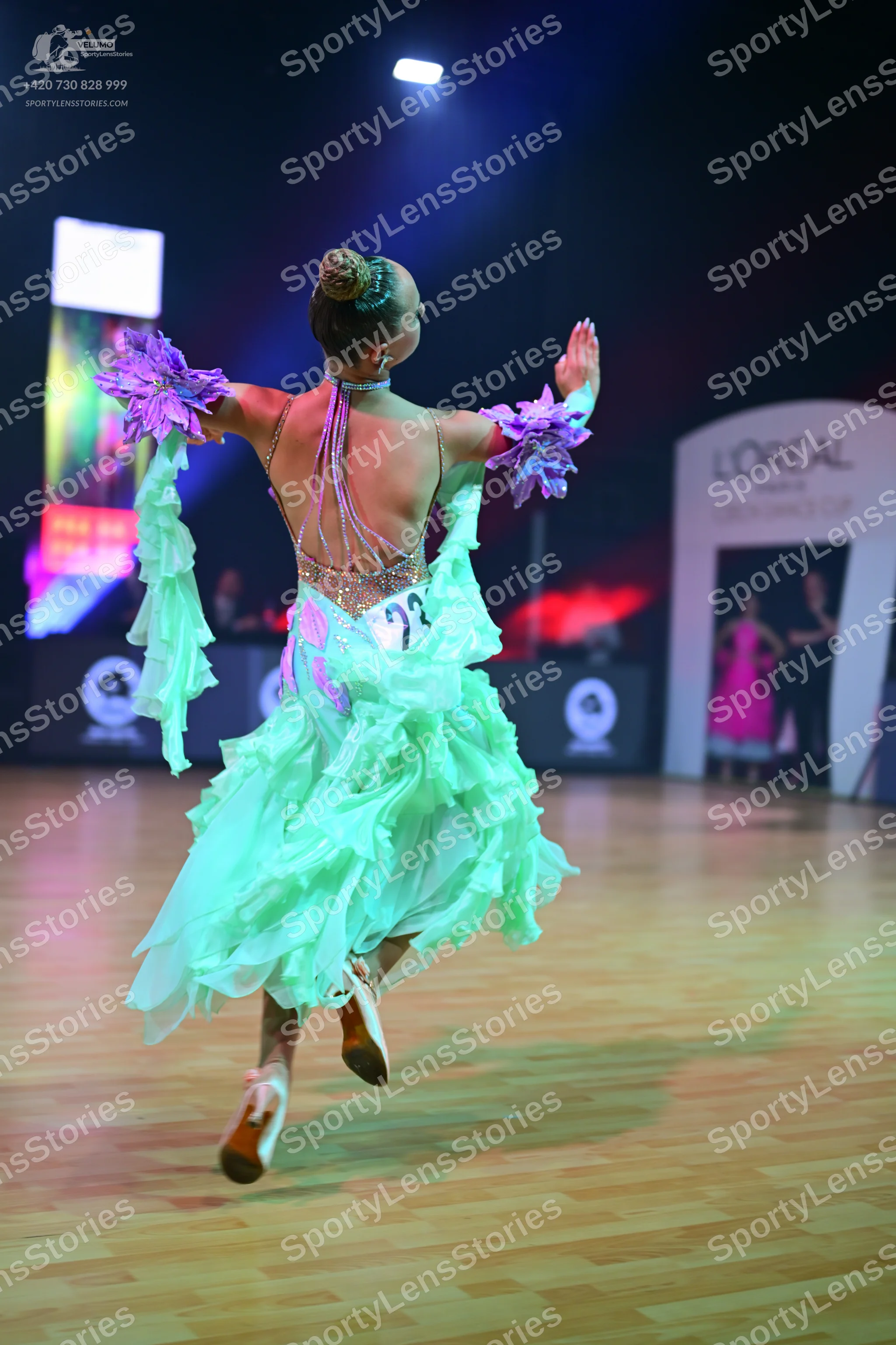 Dancesport competitor: Female dancer: Mint green ruffled ballroom dress with purple floral accents on t