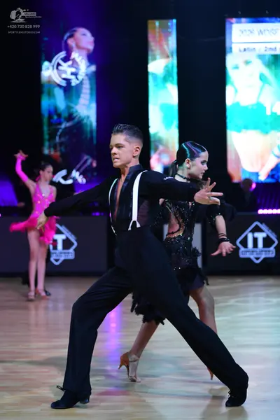 Dancesport competitor: Male dancer: black long-sleeve shirt with white suspenders and black trousers