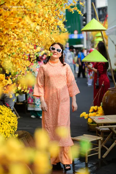 Dancesport competitor: Female dancer: peach-colored, patterned, long-sleeved tunic and matching trouser