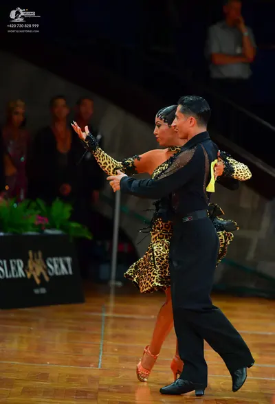 Dancesport competitor: Male dancer: black long-sleeved Latin dance top with sheer mesh panels and cryst